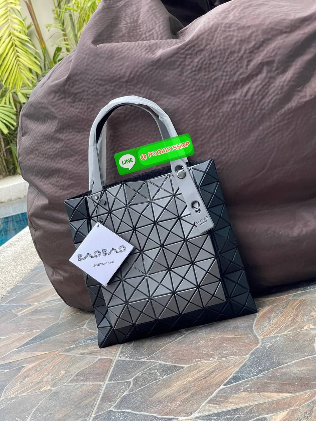 Baobao Issey Miyake Prism Kangaroo tote bag กระเป๋าถือทรงโท้ทที่ประดิษฐ์ขึ้นอย่างเชี่ยวชาญในญี่ปุ่น มาพร้อมแผงเรขาคณิตสำหรับการออกแบบที่ได้รับแรงบันดาลใจจากกระดาษพับ ซิลลูเอทอันเป็นเอกลักษณ์นี้ปิดท้ายด้วยสายรัดแบบอสมมาตร มีการพัฒนาโครงสร้างทรงสามเหลี่ยมเพ