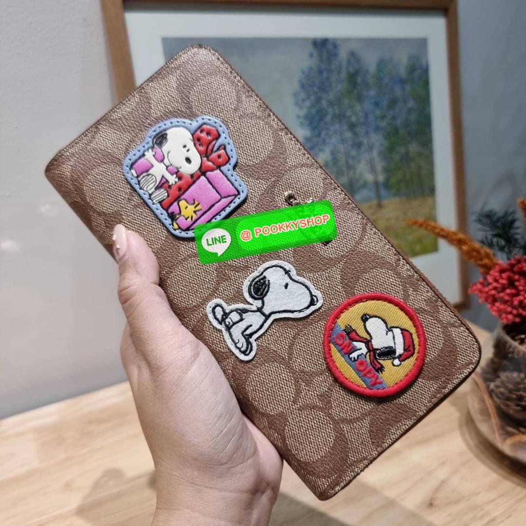 COACH CF218 COACH × PEANUTS LONG ZIP AROUND WALLET IN SIGNATURE CANVAS WITH PATCHES ใหม่ล่าสุด กับกระเป๋าสตางค์ใบยาวกึ่งคล้องมือ สวยดูแพง ดีไซน์ตกแต่งแพทช์เหล่าการ์ตูนยอดฮิต คลาสสิคไม่มีเอาท์ คมชัดมีเลเยอร์ วัสดุหนังแคนวาสเคลือบผิว ดูแลรักษาง่าย มาพร้อมสา