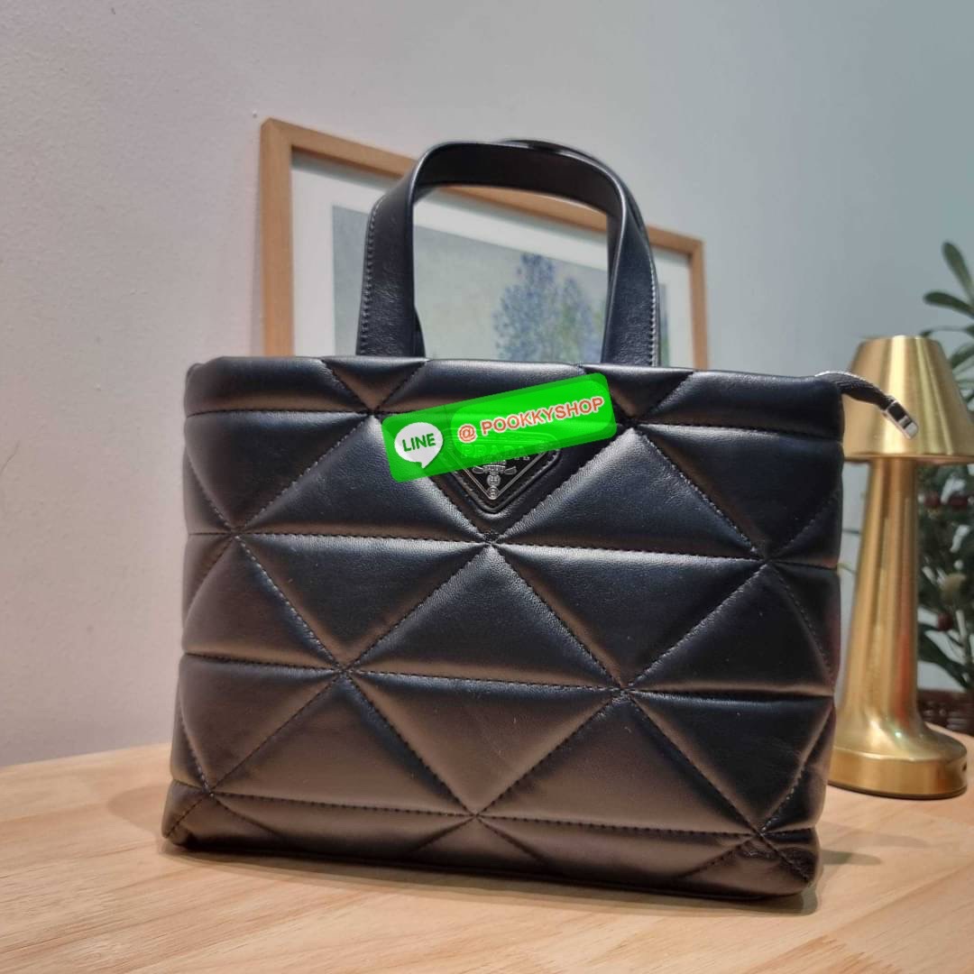 PRADA LEATHER PADDED BAG ใหม่ล่าสุด กับคอลเลคชั่นที่ทำออกมาตอบโจทย์ได้ทุกไลฟ์สไตล์ และเป็นยูนิเซ็กส์ กับกระเป๋าทรงโท้ท ขนาดกำลังดี วัสดุหนังแท้ ตัดเย็บเดินเส้นลายตาราง ปากกระเป๋ามีซิปเปิดปิด ภายในเป็นช่องโล่ง มีช่องแยกให้ มาพร้อมสะพายข้างและใบลูก ให้ได้สน
