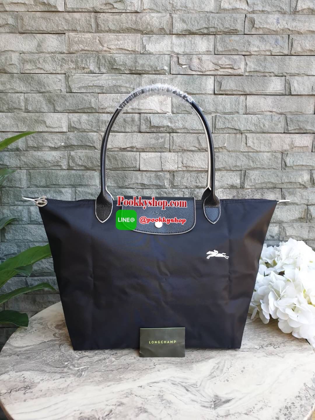 Longchamp Le Pliage Club Tote Bag Size L หูยาว วัสดุเนื้อผ้า Nylon Canvas เคลือบกันนำ้ ตัดด้วยหนังแท้ที่มีน้ำหนักเบา ดีไซน์เรียบง่ายแต่เต็มไปด้วยความคลาสสิก จนเป็นที่ชื่นชอบไปทั่วโลก Longchamp ปรับโฉม LE PLIAGE ด้วยการปักลายรูปม้า-ตราสัญลักษณ์ของแบรนด์บนผ