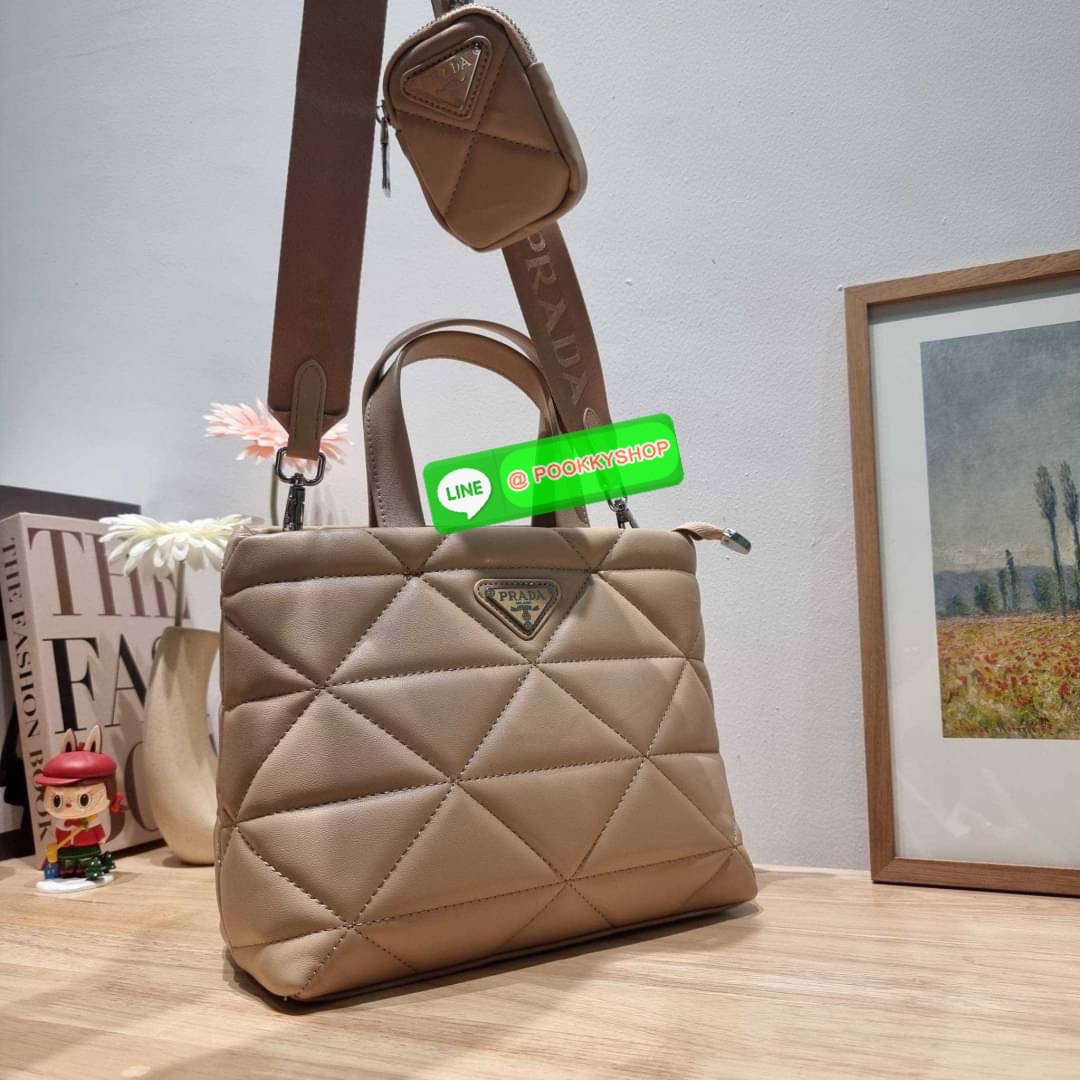PRADA LEATHER PADDED BAG ใหม่ล่าสุด กับคอลเลคชั่นที่ทำออกมาตอบโจทย์ได้ทุกไลฟ์สไตล์ และเป็นยูนิเซ็กส์ กับกระเป๋าทรงโท้ท ขนาดกำลังดี วัสดุหนังแท้ ตัดเย็บเดินเส้นลายตาราง ปากกระเป๋ามีซิปเปิดปิด ภายในเป็นช่องโล่ง มีช่องแยกให้ มาพร้อมสะพายข้างและใบลูก ให้ได้สน