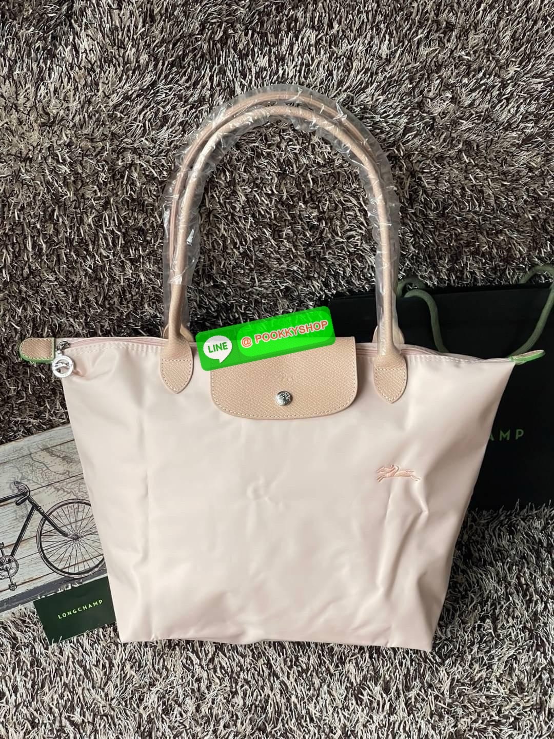 LONGCHAMP LE PLIAGE GREEN Shoulder bag L กระเป๋าโท้ทใบนี้ดึงดูดใจคุณด้วยรูปทรงมินิมอลและปริมาตรที่เพียงพอซึ่งสามารถเก็บเอกสารหรือแล็ปท็อปทั้งหมดของคุณได้อย่างง่ายดาย ด้ามยาวช่วยให้คุณสวมใส่ได้อย่างสบายบนไหล่ ขณะที่การปิดด้วยซิปช่วยให้มั่นใจได้ว่าสิ่งของทั