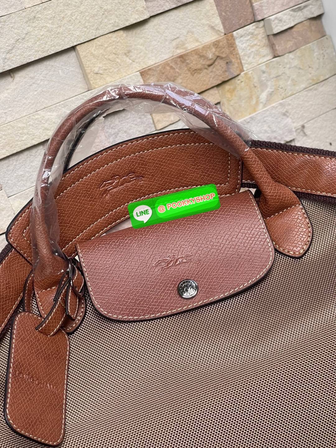 LONGCHAMP BOXFORD TRAVEL BAG L กระเป๋าเดินทางขนาดใหญ่ มาพร้อมสายสะพายที่สามารถถอดได้ ให้คุณเลือกสะพายไหล่หรือถือได้ มีซิปรูดเปิดปิดกระเป๋าที่ให้คุณมั่นใจได้ว่าคุณจัดเก็บไอเท็มของคุณได้อย่างมิดชิด บ็อคฟอร์ด (BOXFORD) สะท้อนความเป็นเอกลักษณ์ของแบรนด์ที่เปี่