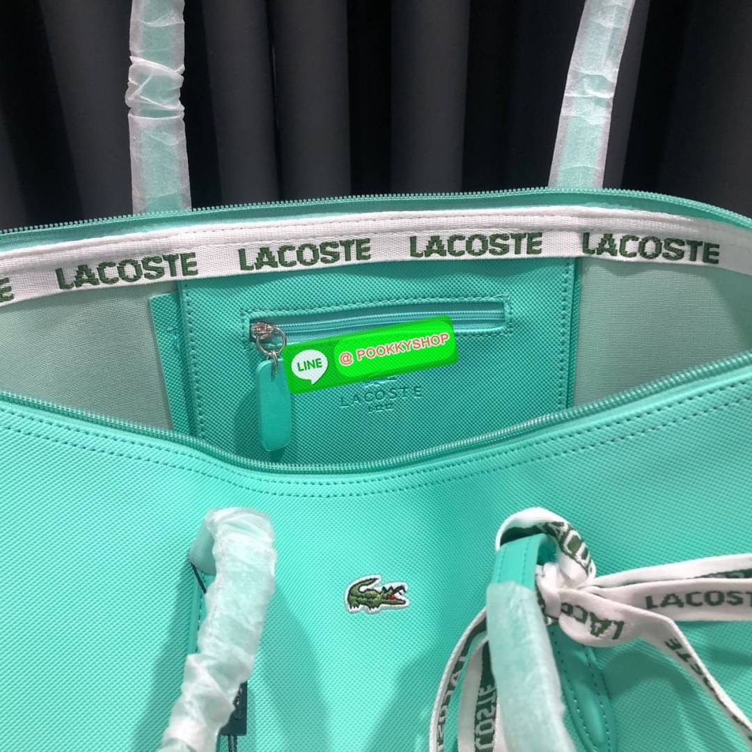 ลาคอส Classic Tote Bag กระเป๋าสะพายทรงช้อปปิ้งหลากสีรุ่นยอดนิยมด้านหน้าประดับโลโก้จระเข้สัญลักษณ์แบรนด์ ภายในกว้างจุได้เยอะ เปิดปิดด้วยซิปสะดวกใช้ มี1 ช่องซิปเล็ก หัวซิปปั้มเเบรนด์ วัสดุกันน้ำ ขนาดกำลังดี ใส่หนังสือ เอกสารA4 ของใช้ได้เยอะ สวยทุกสีค่ะ