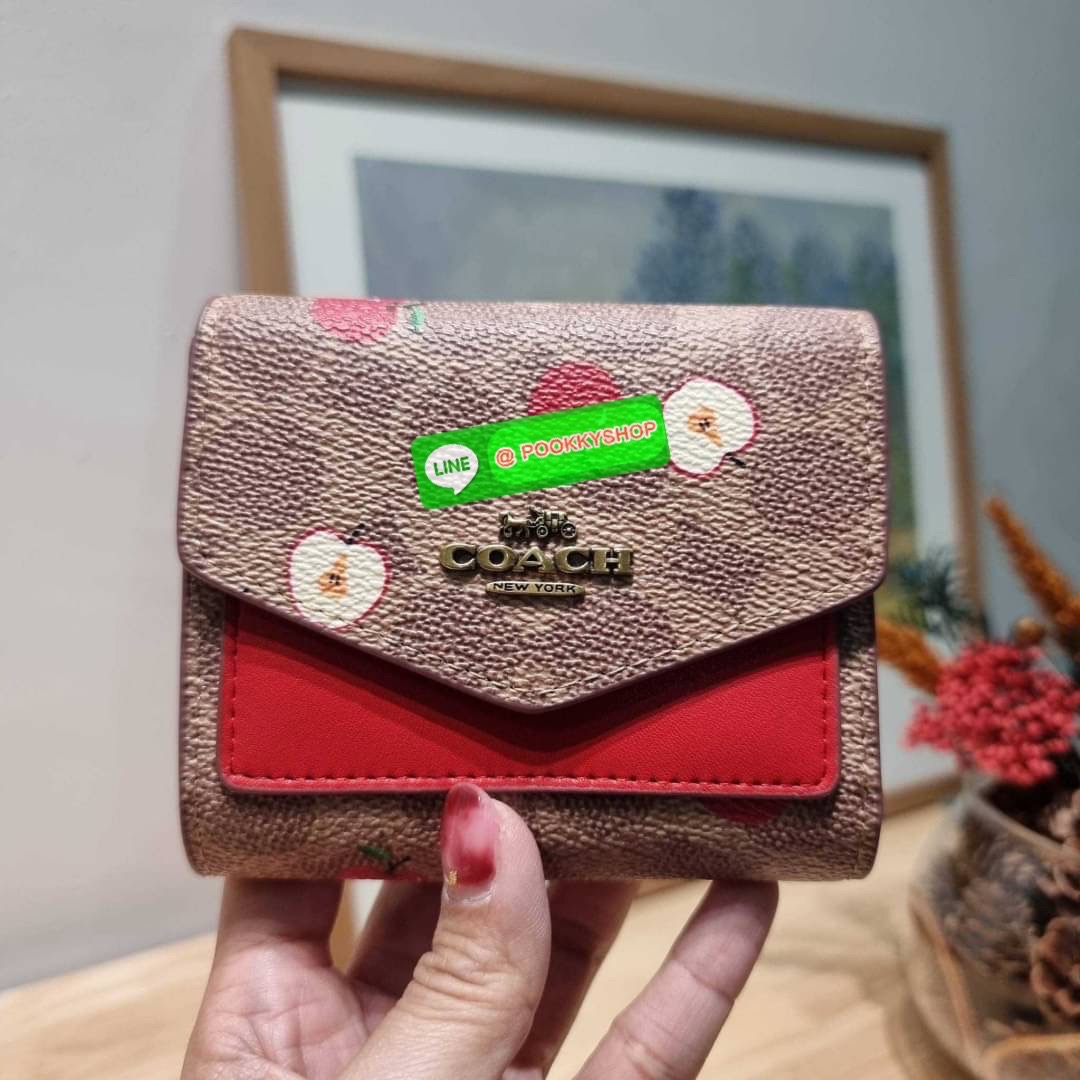 COACH 87709 SMALL WALLET IN SIGNATURE CANVAS WITH SCATTERED APPLE PRINT 🔆 Details กระเป๋าสตางค์ใบสั้น พับสองตอน อะไหล่สีทองเหลือง สวยคลาสสิค แต่งเติมสีสันด้วยแอปเปิ้ลคละเต็มใบ ดูสวยหรูอย่างลงตัว เปิด-ปิดด้วยกระดุม ภายในมีช่องใส่บัตร ใส่ธนบัตรได้ทุ