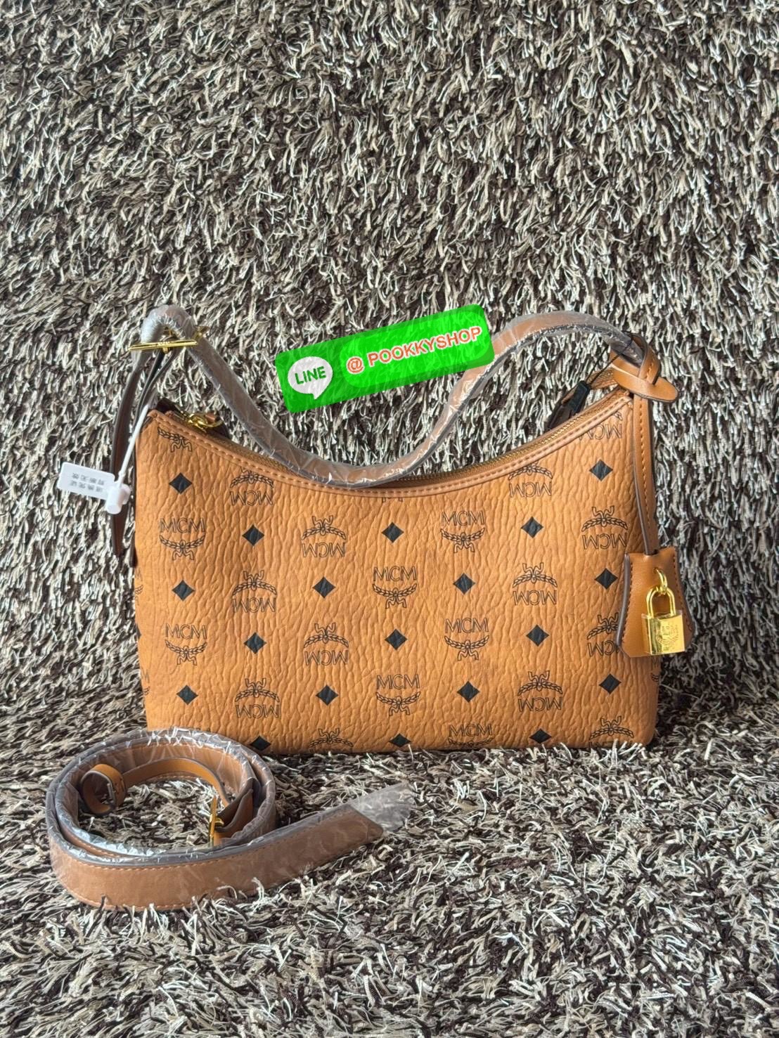 MCM Aren Hobo In Visetos กระเป๋าสไตล์คลาสสิก โดดเด่นด้วยรูปลักษณ์ ที่สามารถสะพายขึ้นไหล่ และยังมีสายสะพายเพิ่มให้1เส้น ต่อเป็นสายยาวสะพายพาดลำตัวได้ ฝากกระเป๋าเปิดปิดด้วยซิป แต่งดีเทลแท็กหนังที่ถอดออกได้และกุญแจพร้อมลูกสลักโลโก้