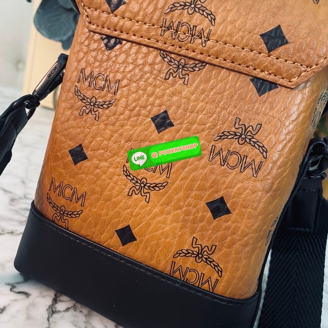 MCM Small Aren N/S Crossbody in Visetos Cognac คอลใหม่เอาใจหนุ่มๆ สั่งก่อนหล่อก่อนน้าา!! กับกระเป๋าสะพายข้างสุดชิค ที่ดูดีมีเสน่ห์มากๆ เห็นแล้วก็ต้องหลงแน่นอน รูปทรงกะทัดรัด สะพายแล้วคล่องตัว เปิด-ปิดด้วยกระดุมแม่เหล็ก ภายในเป็นช่องโล่ง ใส่โทรศัพท์ได้ทุกร