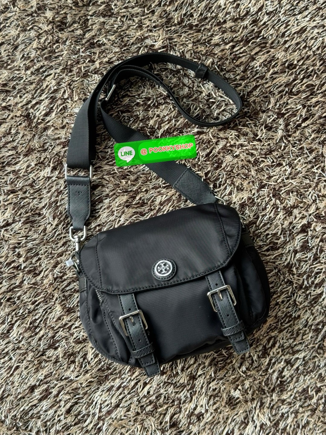 TORY BURCH VIRGINIA SMALL MESSENGER เป็นกระเป๋าที่มีรูปแบบการเปิด-ปิดด้วยกระดุมแม่เหล็ก ทำให้ปากกระเป๋าเปิดง่ายและหยิบสิ่งของสะดวก ซึ่งภายในฐานกระเป๋ามีความกว้างขวางพอสมควร เก็บสิ่งของต่าง ๆ ได้ดั่งใจ มาพร้อมดีไซน์เรียบง่ายสีดำประดับด้วยโลโก้แบรนด์อันเป็น