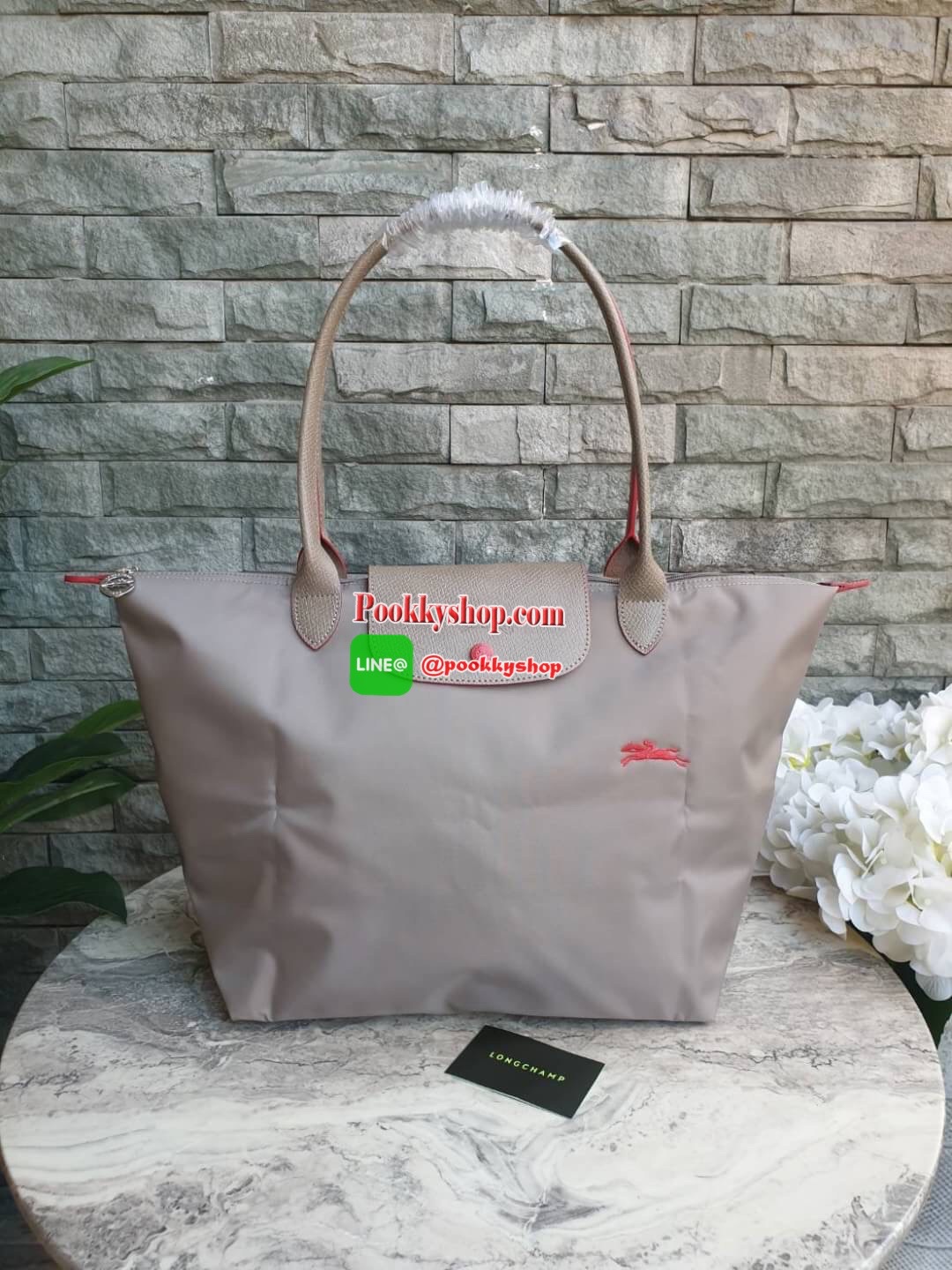 Longchamp Le Pliage Club Tote Bag Size L หูยาว วัสดุเนื้อผ้า Nylon Canvas เคลือบกันนำ้ ตัดด้วยหนังแท้ที่มีน้ำหนักเบา ดีไซน์เรียบง่ายแต่เต็มไปด้วยความคลาสสิก จนเป็นที่ชื่นชอบไปทั่วโลก Longchamp ปรับโฉม LE PLIAGE ด้วยการปักลายรูปม้า-ตราสัญลักษณ์ของแบรนด์บนผ