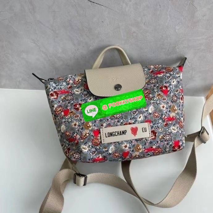 New Arrival Longchamp X Eu Backpack กระเป๋าเป้สะพายหลังลายดอกๆไม้ วัสดุผ้าฝ้าย อะไหล่สีดำ กระเป๋าเป้แบบลำลองสำหรับสตรีซึ่งนำรูปทรงอันเป็นเอกลักษณ์ของ Le Pliage มาปรับใช้กับทุกสถานการณ์ อุปกรณ์เสริมที่ใช้งานได้จริงนี้มีสายรัดปรับระดับได้และที่จับช่วยให้ สะ