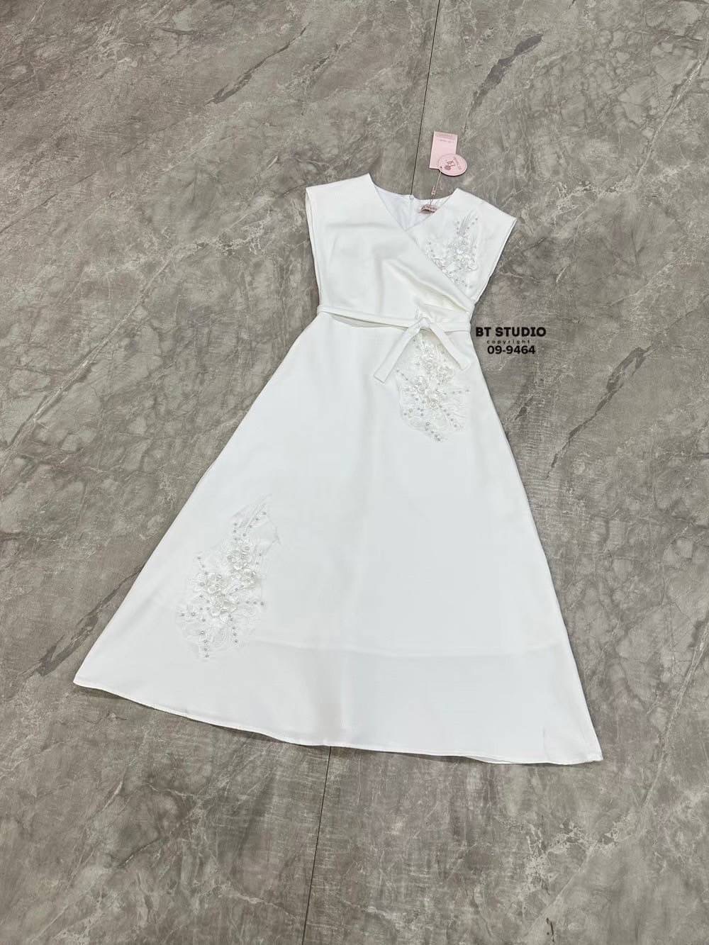 เดรสยาวแขนกุด คอวี ดีไซน์แต่งจับจีบช่วงเอวนึ่งข้าง แต่งปักดอกไม้และมุกด้านหน้าสามจุด ช่วงเอวเข้ารูป ตัวกระโปรงแต่งบานออกเล็กน้อย งานสวยมีซับในซิปหลัง มาพร้อมสายผูกเอว ลุคนี้เรียบหรูดูแพงสุดๆคะ