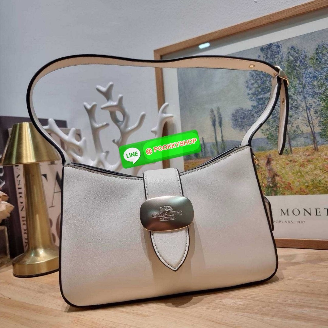 COACH CR533 ELIZA SHOULDER BAG 🔅 Details ใหม่ล่าสุด กระเป๋าสะพายไหล่ทรงโฮโบสุดหรู ดีไซน์โลโก้แบบใหม่และหรูหรายิ่งขึ้น คงความคลาสสิคและวินเทจ เปิด-ปิดด้วยสายคาดแบบกระดุมแม่เหล็ก ภายในเป็นช่องโล่ง แบ่งสัดส่วนไว้อย่างดี มีทั้งช่องใส่บัตร และช่องซิป ส