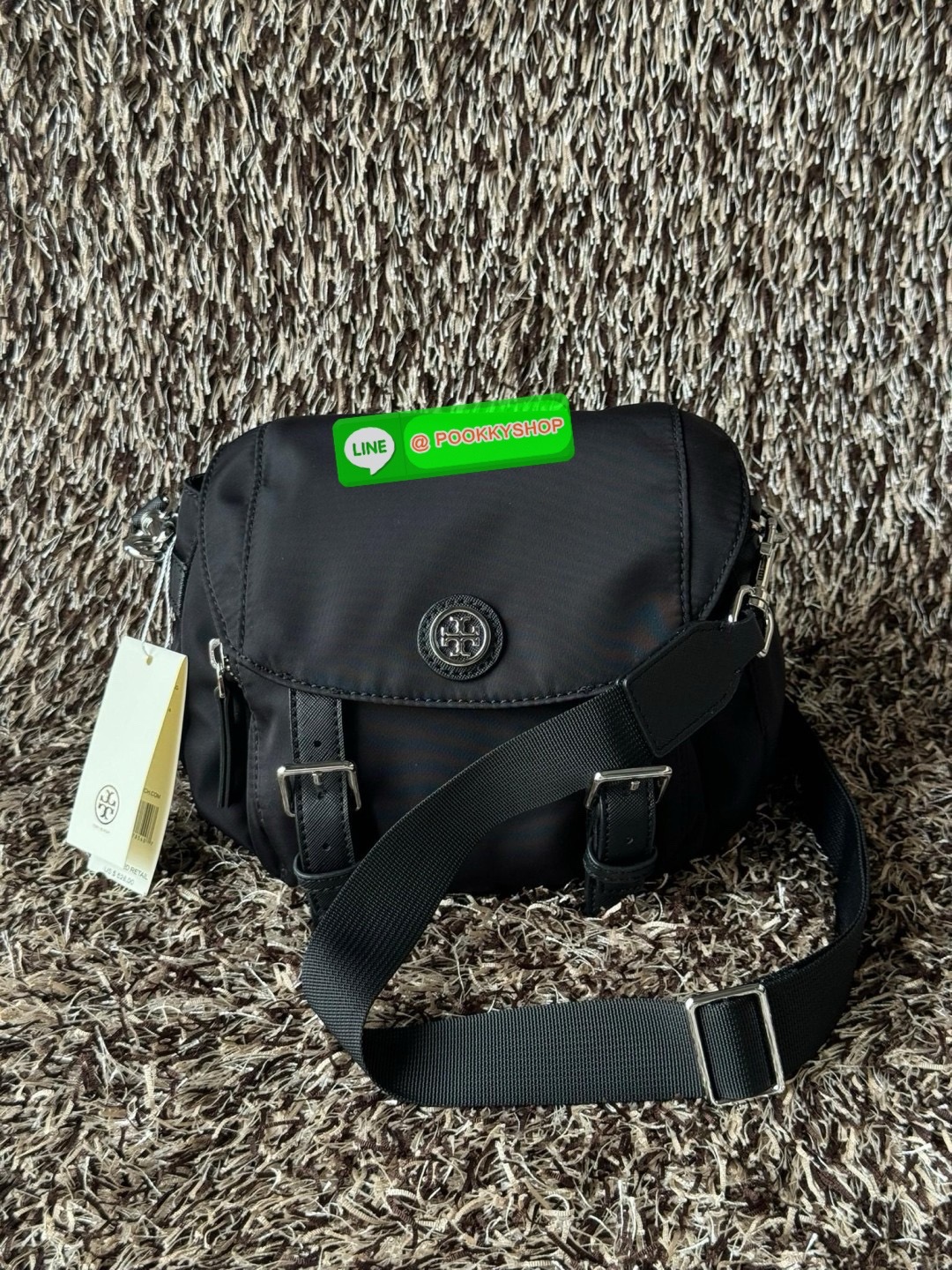 TORY BURCH VIRGINIA SMALL MESSENGER เป็นกระเป๋าที่มีรูปแบบการเปิด-ปิดด้วยกระดุมแม่เหล็ก ทำให้ปากกระเป๋าเปิดง่ายและหยิบสิ่งของสะดวก ซึ่งภายในฐานกระเป๋ามีความกว้างขวางพอสมควร เก็บสิ่งของต่าง ๆ ได้ดั่งใจ มาพร้อมดีไซน์เรียบง่ายสีดำประดับด้วยโลโก้แบรนด์อันเป็น