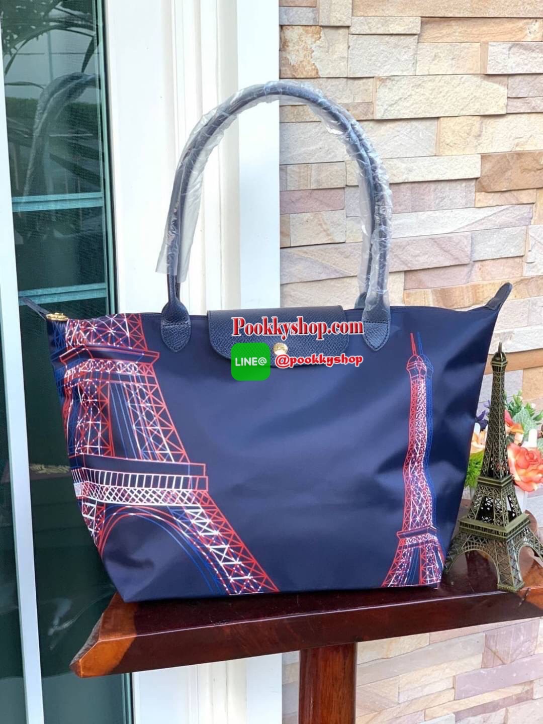 Longchamp Made In France Le Pliage Eiffel Tower Limited Edition Tote Bag สุดลิมิเตทกับlongchamp ที่ ออกมาเฉพาะซีซั่น พิมพ์ลายหอไอเฟล สามาถพับเก็บได้ ตรงตามชื่อทรง (คำว่า Le Pliage เป็นภาษาฝรั่งเศส แปลว่าการพับ) ส่วนฝาปิดและหูจับเป็นหนังที่ทำให้กระเป๋าดูไม