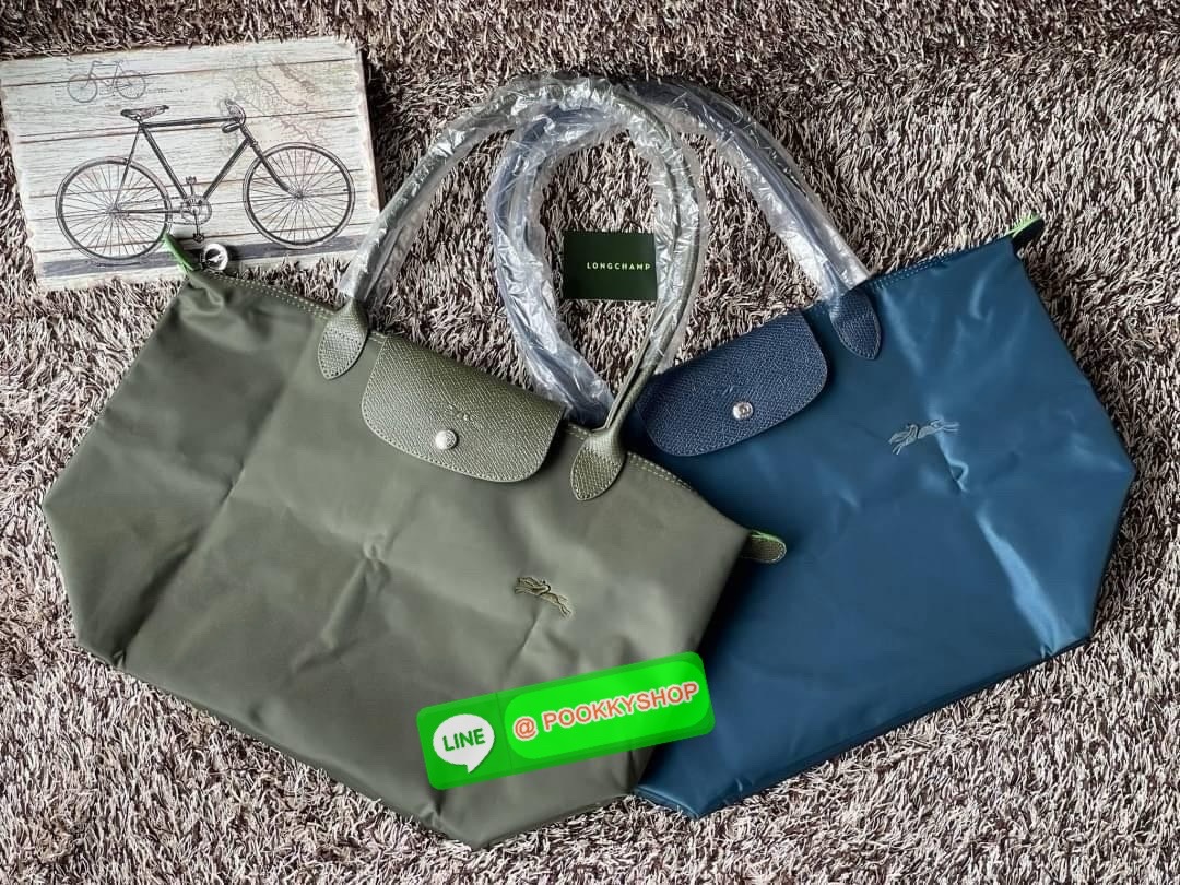 LONGCHAMP LE PLIAGE GREEN Shoulder bag L กระเป๋าโท้ทใบนี้ดึงดูดใจคุณด้วยรูปทรงมินิมอลและปริมาตรที่เพียงพอซึ่งสามารถเก็บเอกสารหรือแล็ปท็อปทั้งหมดของคุณได้อย่างง่ายดาย ด้ามยาวช่วยให้คุณสวมใส่ได้อย่างสบายบนไหล่ ขณะที่การปิดด้วยซิปช่วยให้มั่นใจได้ว่าสิ่งของทั