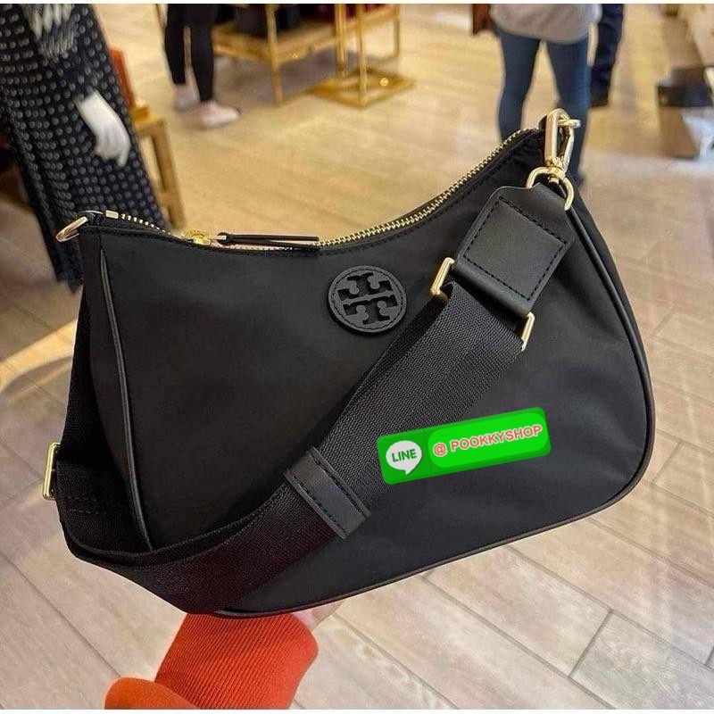 Tory burch nylon web mini hobo เป็นอีกหนึ่งตัวเลือกที่น่าสนใจสำหรับคนที่กำลังมองหากระเป๋าที่เน้นการใช้งาน ดีไซน์เรียบง่าย น้ำหนักเบา เน้นการใช้งานเป็นหลัก อีกทั้งยังมีสายสะพายแบบสปอร์ตช่วยคุณสะพายบนไหล่หรือครอสบอดี้ได้สะดวก ที่สำคัญ ผลิตจากผ้าไนลอนที่มีคว