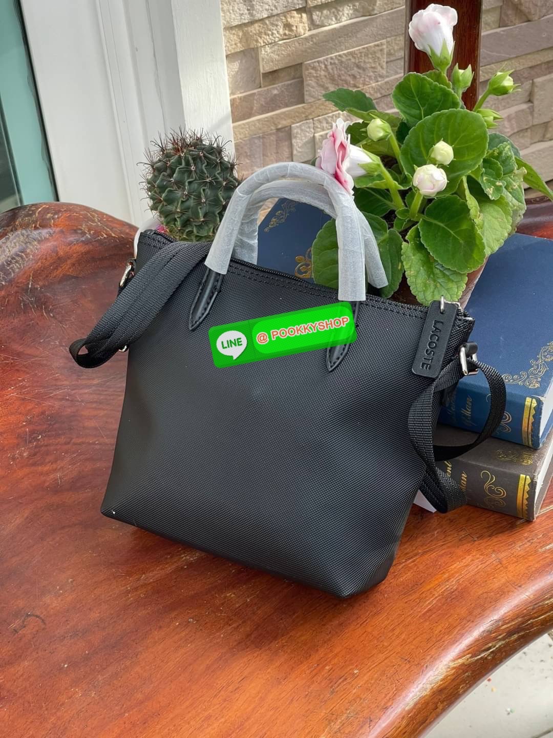 ลาคอส Women's L.12.12 Concept Petit Piqué Zip Tote กระเป๋าสะพายข้างทรง mini tote วัสดุ pvc100% เปิดปิดด้วยซิปเดียวด้านบนสะดวกใช้งาน ใส่มือถือได้ทุกรุ่น ด้านหน้ามีดีเทลโลโก้ปักดูโดดเด่น สายของกระเป๋ารุ่นนี้สามารถปรับความยาวได้ฟรีไซส์ เลือกสะพายได้ ไ