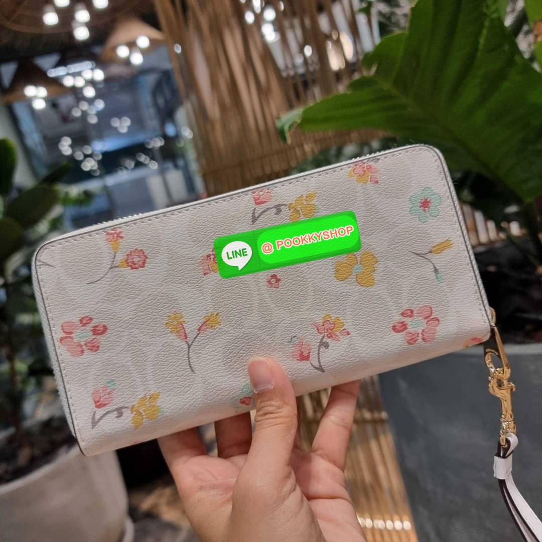 COACH C8695 LONG ZIP AROUND WALLET IN SIGNATURE CANVAS WITH MYSTICAL FLORAL PRINT พร้อมเสิร์ฟความหรู กับคอลใหม่ล่าสุด กระเป๋าสตางค์ใบยาวกึ่งคล้องมือ มาในดีไซน์ผู้ดี เรียบหรู ถือใช้แล้วขับผิวมาก ลวดลายดอกไม้คละเคล้าสวยงาม วัสดุหนังแคนวาสเคลือบลาย มาพร้อมสา