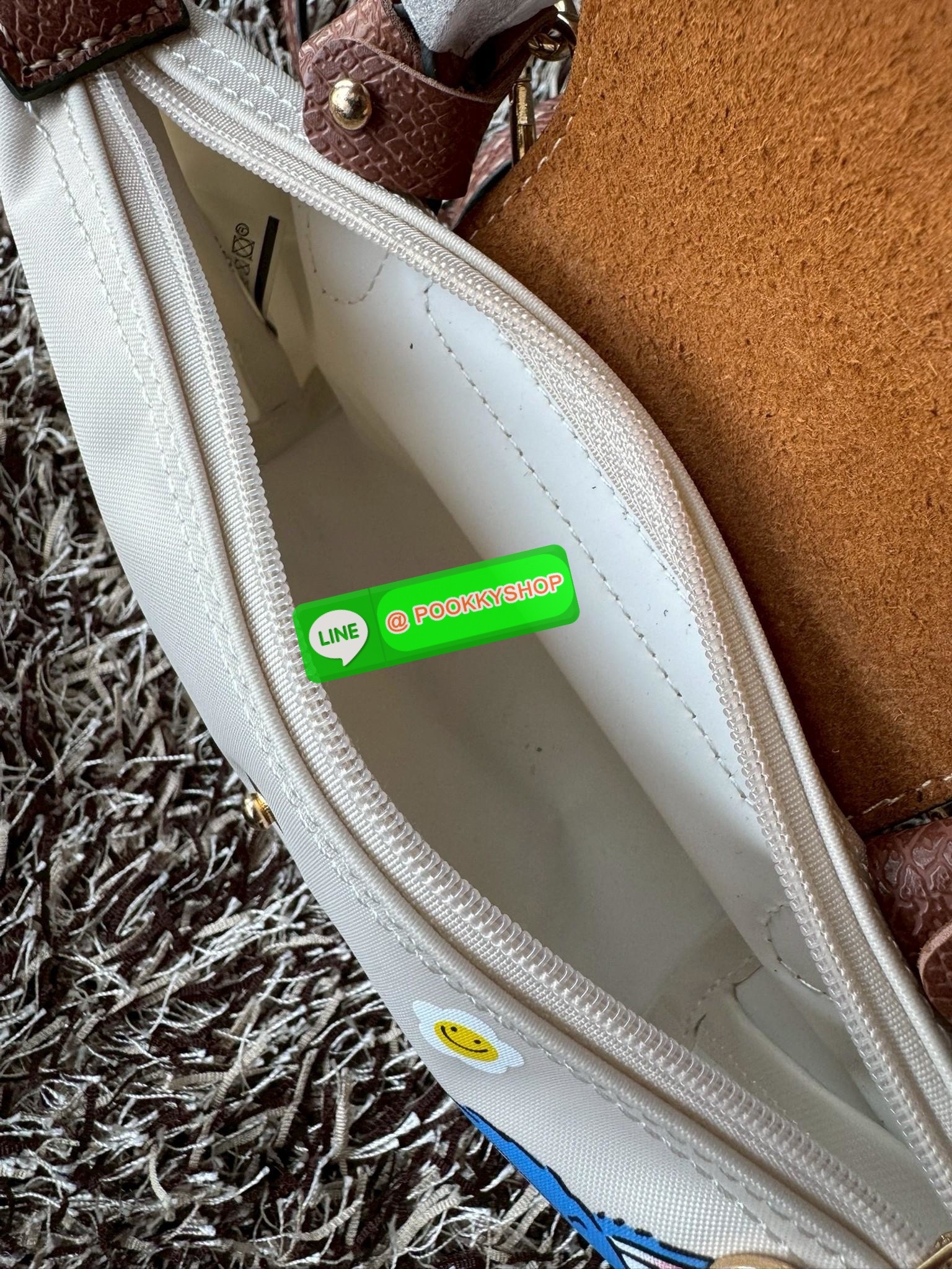 LONGCHAMP LE PLIAGE ORIGINAL X Labubu Pouch with handle เป็นการร่วมงานกัระหว่างแบรนด์ และยังกระเป๋าถือขนาดมินิทรงpouch ที่ด้านหน้ามีลวดลายน้องลาบูบู้ในแบบต่างๆ เปิดปิดระบบสองชั้น ได้ว่าของด้านในมีความปลอดภัย เหมาะอย่างยิ่งสำหรับสาวๆที่ชอบกระเป๋าขนาดมินิไซ