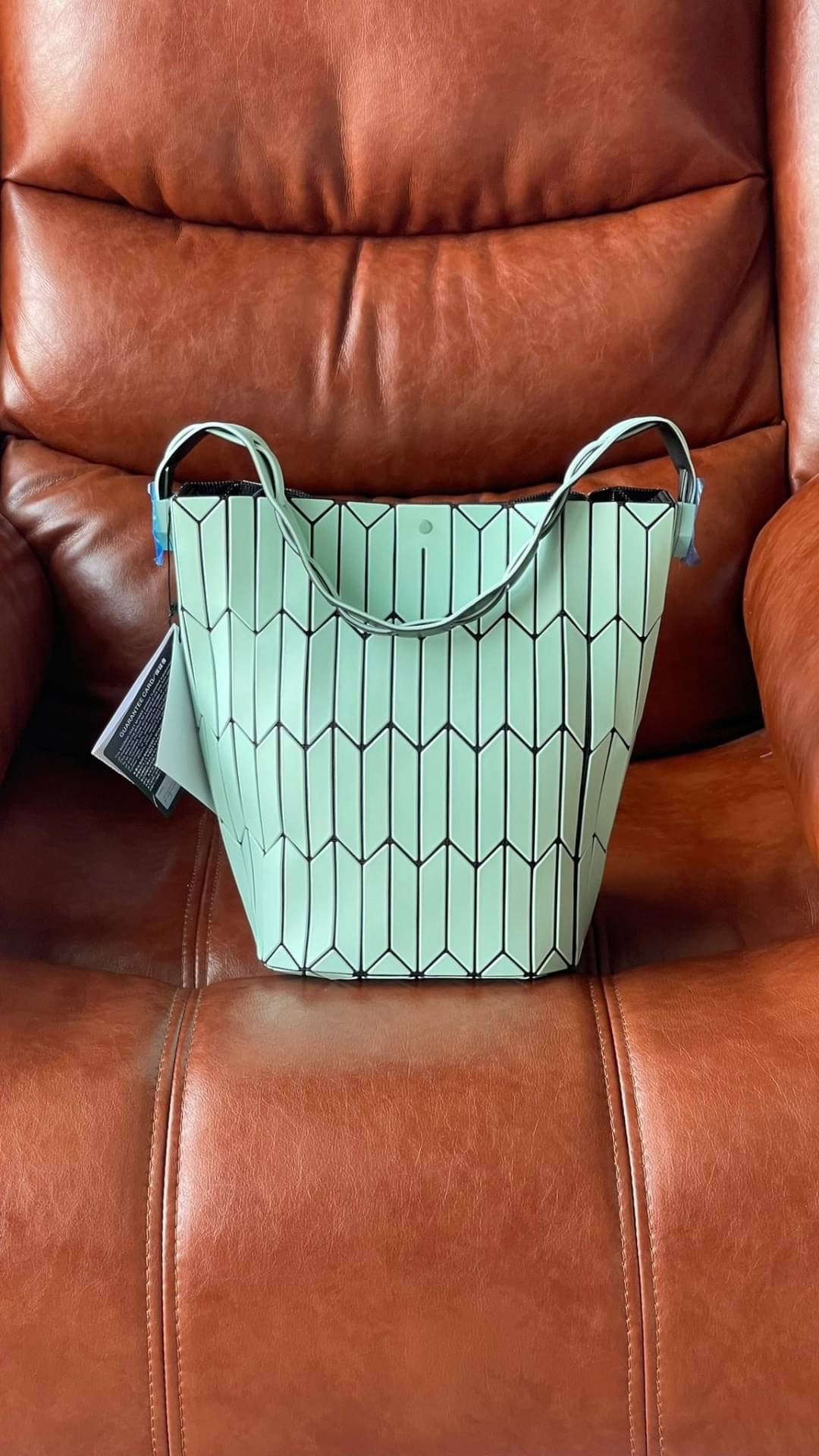 💕Baobao Issey Miyake Large Bucket กระเป๋าบัคเก็ตขนาดใหญ่สามารถใช้ใส่ร่มพับได้หรือขวดน้ำขนาดเล็กได้ ซีรีย์ใหม่นี้มีจุดเด่นที่แผ่นรูปทรงสี่เหลี่ยมด้านขนานในแนวตั้ง เกิดเป็นรูปทรงสามมิติซึ่งแตกต่างไปจากรูปทรงที่เกิดขึ้นจากแผ่นสามเหลี่ยม หูหิ้วสามารถข