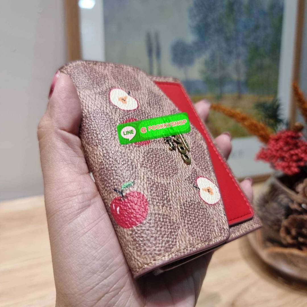 COACH 87709 SMALL WALLET IN SIGNATURE CANVAS WITH SCATTERED APPLE PRINT 🔆 Details กระเป๋าสตางค์ใบสั้น พับสองตอน อะไหล่สีทองเหลือง สวยคลาสสิค แต่งเติมสีสันด้วยแอปเปิ้ลคละเต็มใบ ดูสวยหรูอย่างลงตัว เปิด-ปิดด้วยกระดุม ภายในมีช่องใส่บัตร ใส่ธนบัตรได้ทุ