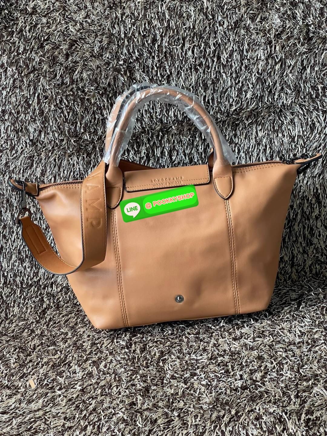 Longchamp LE PLIAGE CUIR TOP HANDLE BAG S เรียกว่าเป็นกระเป๋าอีกหนึ่งรุ่นที่ไม่ว่ายังไงก็ฮอตฮิตและติดเทรนด์ตลอดไม่เคยเปลี่ยนกับ ทรง Le Pliage Cuir หนึ่งในตระกูลกระเป๋าสุดไอคอนิกจากแบรนด์ เมื่อรุ่น Le Pliage Cuir ในรูปแบบของหนังแกะ Metis ได้ถือกำเนิดขึ้นใน