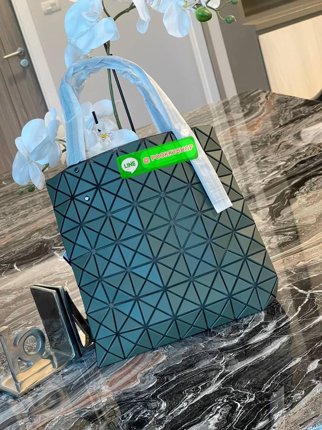 Baobao Issey Miyake Prism Kangaroo tote bag กระเป๋าถือทรงโท้ทที่ประดิษฐ์ขึ้นอย่างเชี่ยวชาญในญี่ปุ่น มาพร้อมแผงเรขาคณิตสำหรับการออกแบบที่ได้รับแรงบันดาลใจจากกระดาษพับ ซิลลูเอทอันเป็นเอกลักษณ์นี้ปิดท้ายด้วยสายรัดแบบอสมมาตร มีการพัฒนาโครงสร้างทรงสามเหลี่ยมเพ