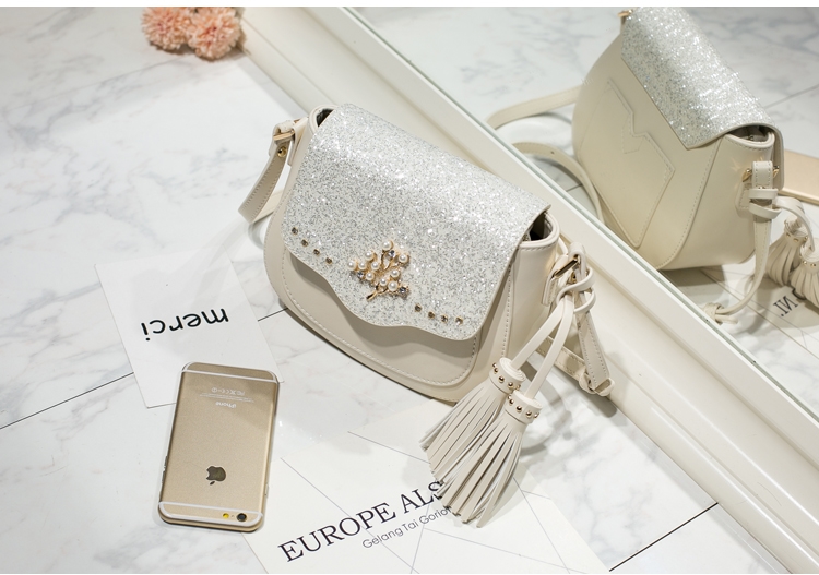 AXIXI กระเป๋าแฟชั่นสตรี รุ่น Tree Pearl สีขาว Off White กระเป๋าสะพายแฟชั่นทรง Saddle สุดน่ารัก เพิ่มความโดดเด่นให้กระเป๋าด้วย Daimond Dust สุดหรูหรา เพิ่มดีเทลให้กับกระเป๋าด้วยอุปกรณ์แต่งกระเป๋าลายต้นไม้สีทองประดับด้วยมุขดูสวยงาม ตัวกระเป๋าผลิตจากหนัง PU