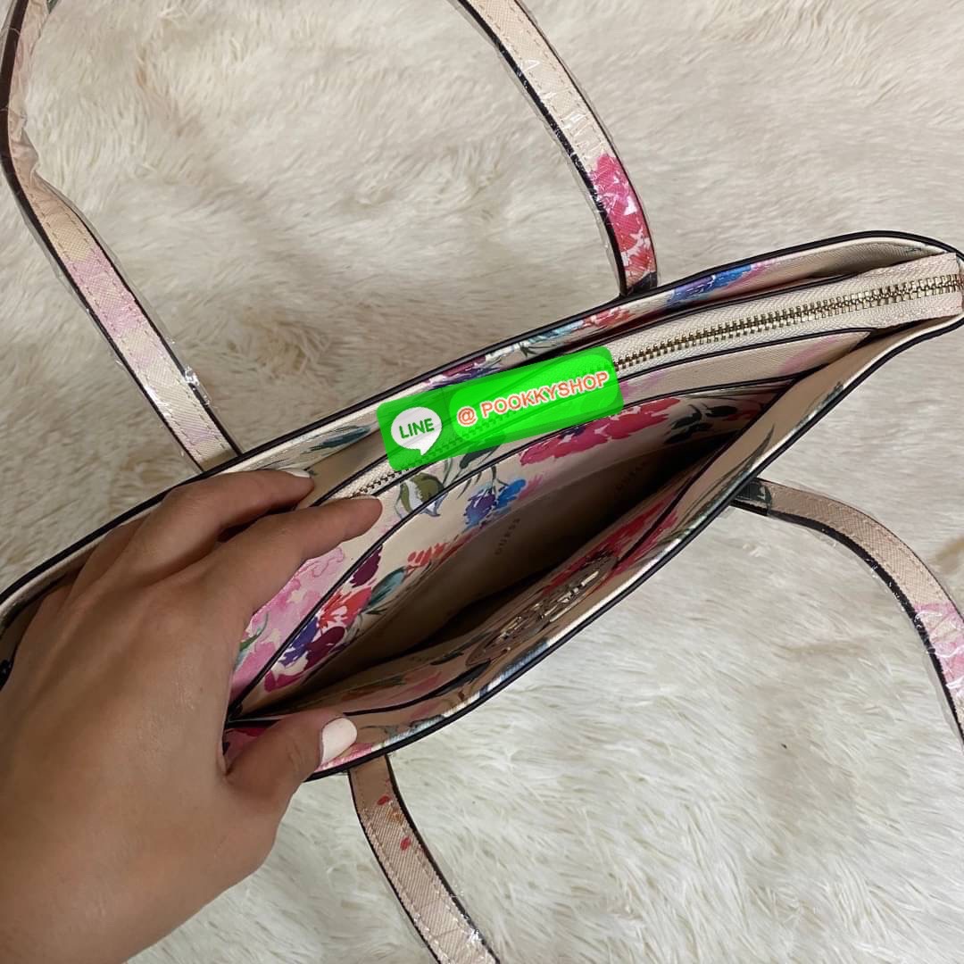 GUESS OPEN ROAD FLORAL TOTE BAG กระเป๋าถือขนาดกลางทรงสวย ฐานตั้งอยู่ทรง สะพายไหล่ได้ วัสดุหนังซาฟิโน่แต่งลายดอกไม้สดใส ด้านหน้าติดโลโก้ลายฉลุสีทองทรงกลมเพิ่มความหรูหรา เปิดปิดด้วยซิปเป็นหลัก ด้านในมีช่องซิป ใส่กระเป๋าสตางค์ มือถือ นิตยสาร ของใช้จุกจิกได้เ