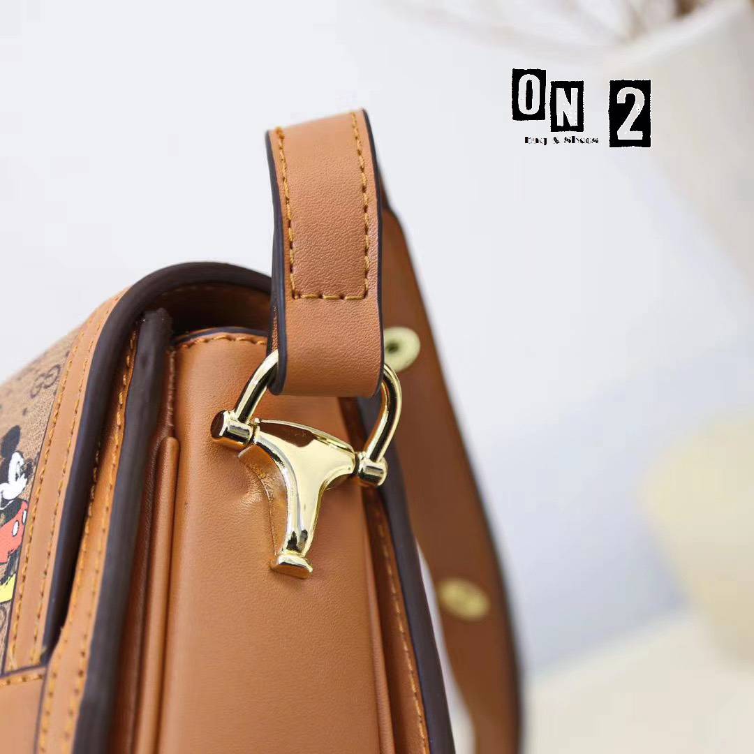 กุชชี่สะพายข้างทรงฝาปิดวัสดุตัวกระเป๋าทำจากหนังแคนวาสลายมิกกี้เม้าส์ อะหลั่ยสีทอง ด้านในซับผ้าทออย่างหนา งานปั๊มทุกจุด สายยาวเป็นหนังอย่างดีสีน้ำตาล