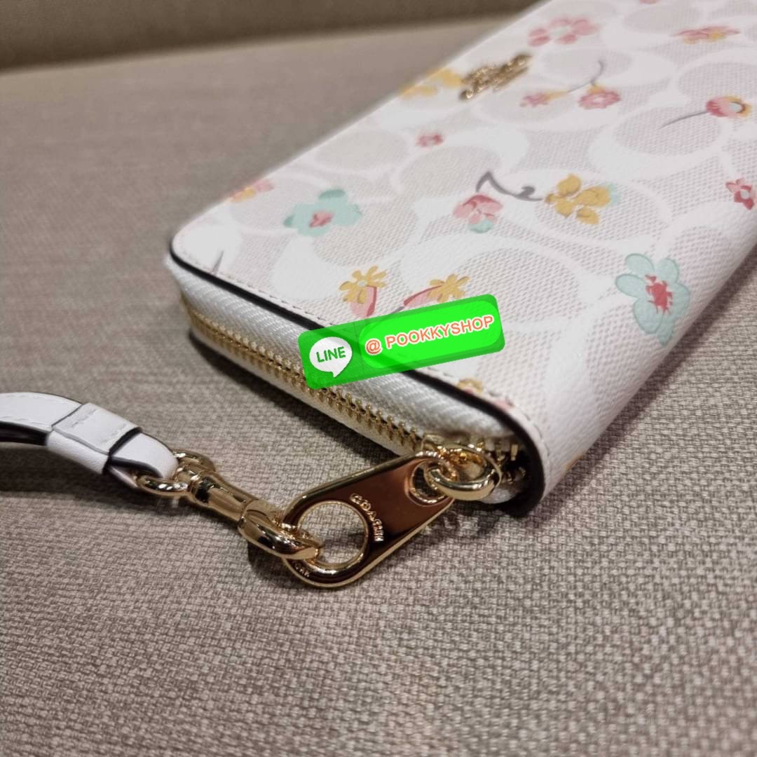 COACH C8695 LONG ZIP AROUND WALLET IN SIGNATURE CANVAS WITH MYSTICAL FLORAL PRINT พร้อมเสิร์ฟความหรู กับคอลใหม่ล่าสุด กระเป๋าสตางค์ใบยาวกึ่งคล้องมือ มาในดีไซน์ผู้ดี เรียบหรู ถือใช้แล้วขับผิวมาก ลวดลายดอกไม้คละเคล้าสวยงาม วัสดุหนังแคนวาสเคลือบลาย มาพร้อมสา
