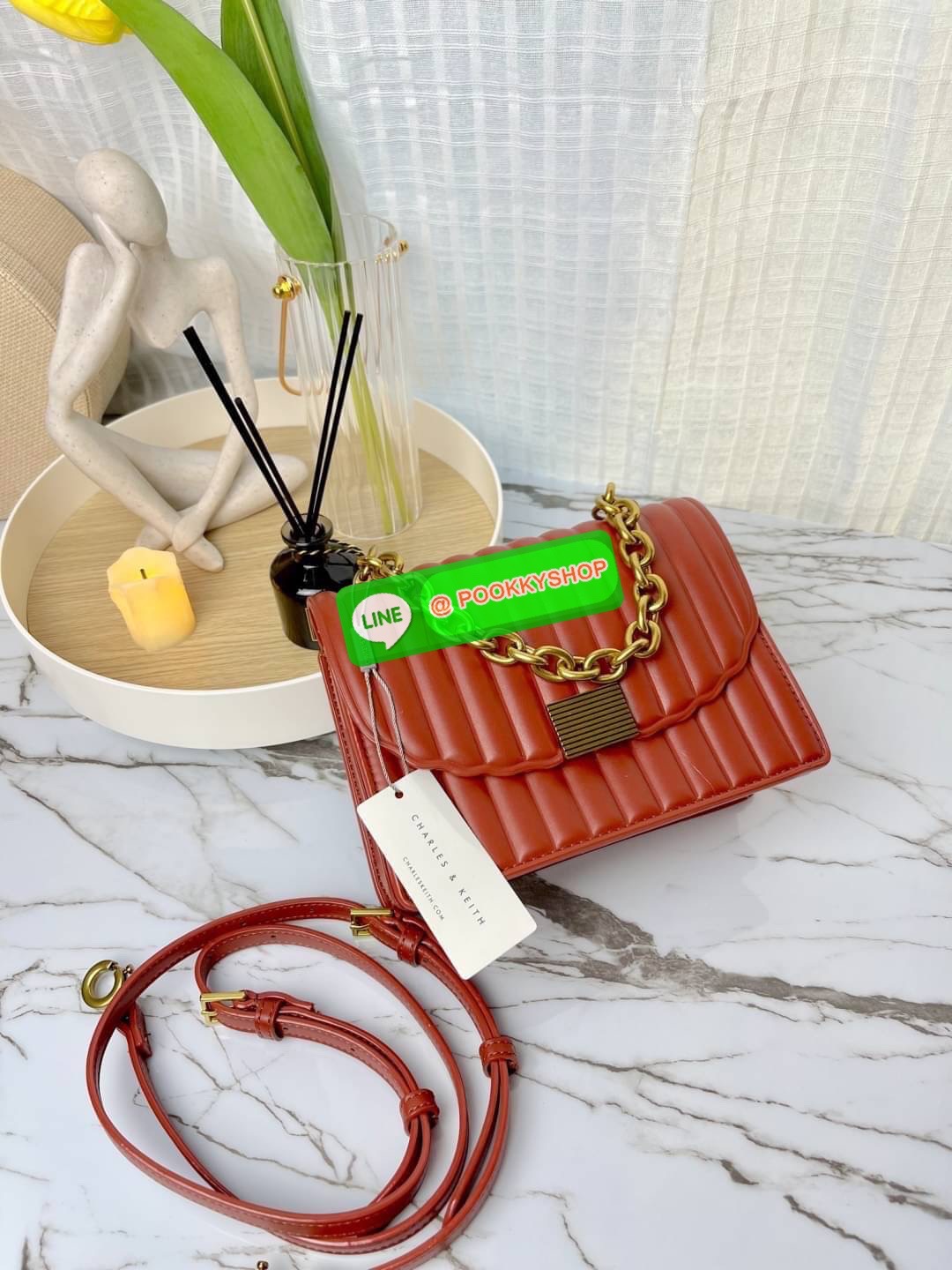 Charles & Keith Panelled Chain Handle Bag กระเป๋าสะพายรุ่นใหม่ชนช็อป รุ่นนี้จะถือคล้องแขน/สะพายแบบสายยาวได้หลายแบบ มีหูโซ่สีทองสวยหรู เปิดปิดแบบตัวเปิดล็อก ภายในแบ่งเป็น 3 ช่อง เป็นช่องซิปตรงกลาง ใส่ IPhone pro max และกระเป๋าเงินใบสั้นได้ค่ะ สายสะพายยาวถอ