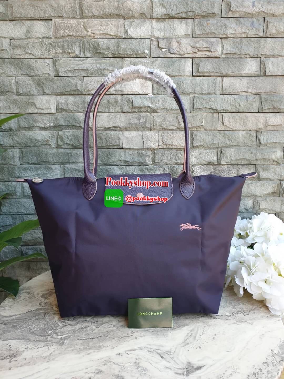 Longchamp Le Pliage Club Tote Bag Size L หูยาว วัสดุเนื้อผ้า Nylon Canvas เคลือบกันนำ้ ตัดด้วยหนังแท้ที่มีน้ำหนักเบา ดีไซน์เรียบง่ายแต่เต็มไปด้วยความคลาสสิก จนเป็นที่ชื่นชอบไปทั่วโลก Longchamp ปรับโฉม LE PLIAGE ด้วยการปักลายรูปม้า-ตราสัญลักษณ์ของแบรนด์บนผ