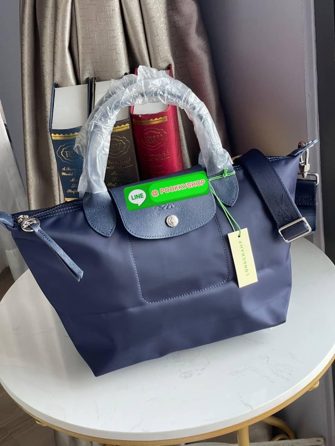 💕Longchamp LE PLIAGE NÉO TOP HANDLE BAG (small size) อีกหนึ่งรุ่นยอดนิยม ที่สาวๆ ต้องมีไว้เก็บไว้สักใบ กระเป๋าโท้ทใบนี้ มาพร้อมกับสีที่มีสไตล์เรียบง่าย มีสายสะพายยาวปรับสั้นยาวได้ช่วยให้คุณสามารถสะพายไหล่ได้อย่างสบาย ในตัวสายปักโลโก้อันเป็นสัญลักษ