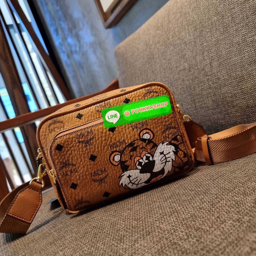 MCM KLASSIK CROSSBODY IN NEW YEAR TIGER VISETOS ใหม่ล่าสุด คอลเลคชั่นรับปีเสือ ของมันต้องมี กระเป๋าสะพายข้างทรงครอสบอดี้ โดดเด่นด้วยลายพริ้นท์น้องเสือคมสวย รุ่นนี้หนุ่มๆหรือสาวๆก็สะพายได้น้า ขนาดกำลังดี วัสดุหนังแคนวาสคุณภาพดี มีช่องหลัก 2 ช่อง เปิด-ปิดด้