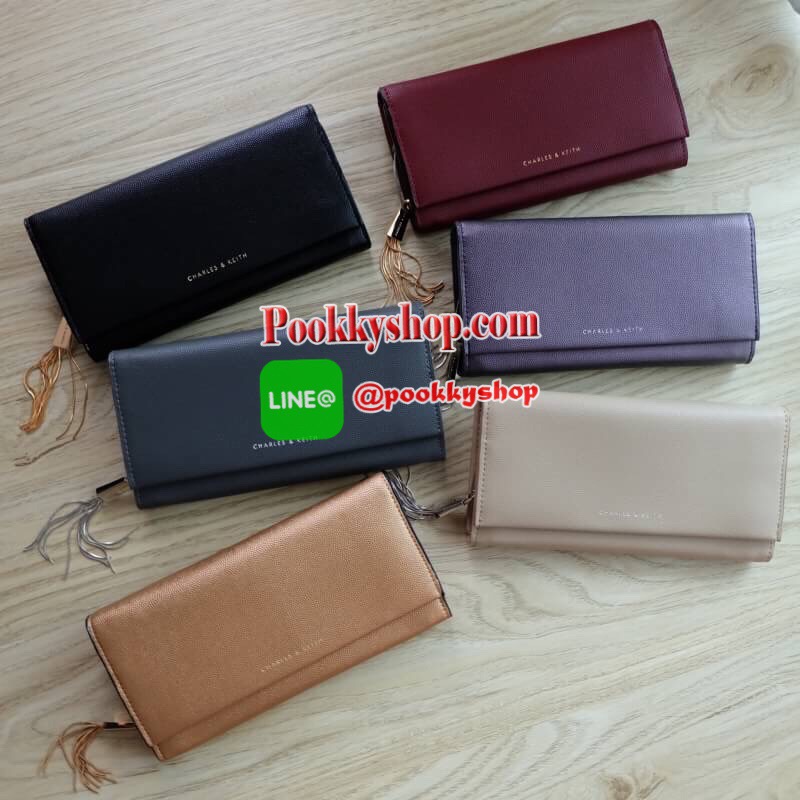 Charles & Keith Basic Long Wallet กระเป๋าสตางค์ใบยาว วัสดุหนังลายคาเวียร์ ตกแต่งด้วยพู่ เปิด – ปิดกระเป๋าด้วยเเม่เหล็กแบบซ่อน ภายในมีช่องใส่บัตร ช่องซิปใส่เหรียญ และช่องใส่ธนบัตร ใส่ iPhone Plus ได้ค่ะ ด้านหลังมีช่อง 1 ช่อง