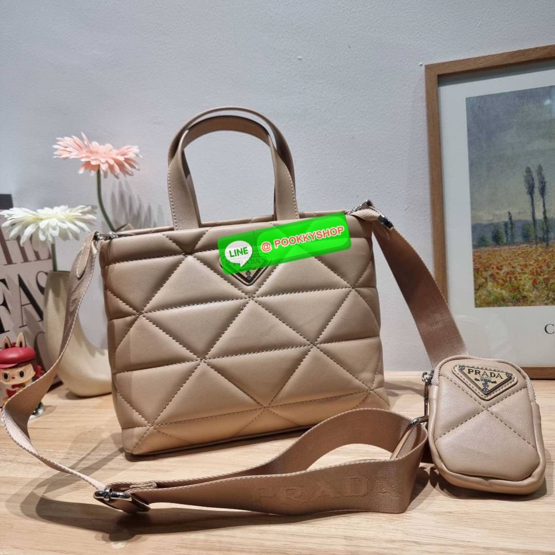 PRADA LEATHER PADDED BAG ใหม่ล่าสุด กับคอลเลคชั่นที่ทำออกมาตอบโจทย์ได้ทุกไลฟ์สไตล์ และเป็นยูนิเซ็กส์ กับกระเป๋าทรงโท้ท ขนาดกำลังดี วัสดุหนังแท้ ตัดเย็บเดินเส้นลายตาราง ปากกระเป๋ามีซิปเปิดปิด ภายในเป็นช่องโล่ง มีช่องแยกให้ มาพร้อมสะพายข้างและใบลูก ให้ได้สน