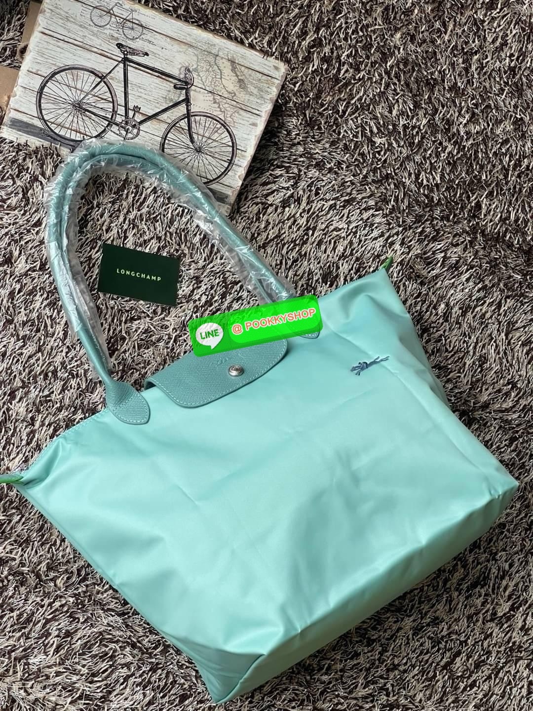 LONGCHAMP LE PLIAGE GREEN Shoulder bag L กระเป๋าโท้ทใบนี้ดึงดูดใจคุณด้วยรูปทรงมินิมอลและปริมาตรที่เพียงพอซึ่งสามารถเก็บเอกสารหรือแล็ปท็อปทั้งหมดของคุณได้อย่างง่ายดาย ด้ามยาวช่วยให้คุณสวมใส่ได้อย่างสบายบนไหล่ ขณะที่การปิดด้วยซิปช่วยให้มั่นใจได้ว่าสิ่งของทั