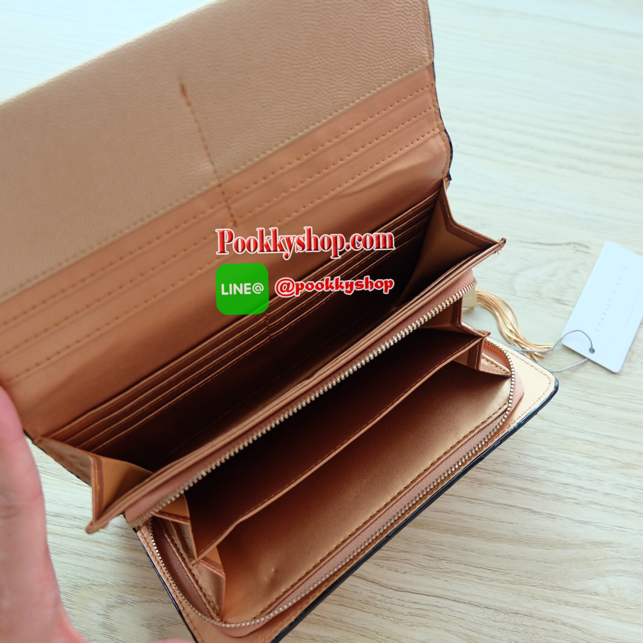 Charles & Keith Tassel Long Wallet กระเป๋าสตางค์ใบยาว วัสดุหนังลายคาร์เวียร์ ตกแต่งด้วยพู่สีทอง เปิด – ปิดกระเป๋าด้วยเเม่เหล็กแบบซ่อน ภายในมีช่องใส่บัตร ช่องซิปใส่เหรียญ และช่องใส่ธนบัตร ใส่ iPhone 7+ ได้ค่ะ ด้านหลังมีช่อง 1 ช่อง