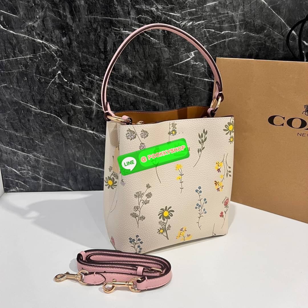 COACH C3598 SMALL TOWN BUCKET WITH SPACED WILDFLOWER PRINT มีความน่ารักละมุนมาก กระเป๋าทรงบัคเก็ต ดีไซน์ดอกไม้คละรอบใบ วัสดุหนังแท้ปากกระเป๋าเปิด-ปิดด้วยกระดุมแม่เหล็ก 2 มีหูจับในตัวและสายสะพายข้าง ภายในโล่งกว้าง มีช่องซิปแยกสัดส่วนตรงกลาง สายสะพายปรับระด