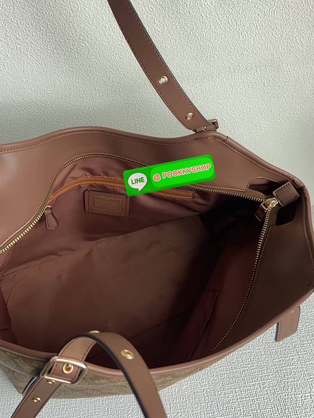 รุ่น: Coach CM076 – Gallery Tote In Signature Canvas • รายละเอียด: กระเป๋าทรง Tote รุ่น Gallery ลาย Signature Canvas คลาสสิก ตัดขอบหนังแท้สีดำเข้ม สายสะพายคู่ปรับระดับได้ ภายในกว้าง ใส่ของทำงานหรือเรียนได้สบาย มีช่องซิปหลัก 1 ช่อง และช่องเสริมด้านในอีกหลา