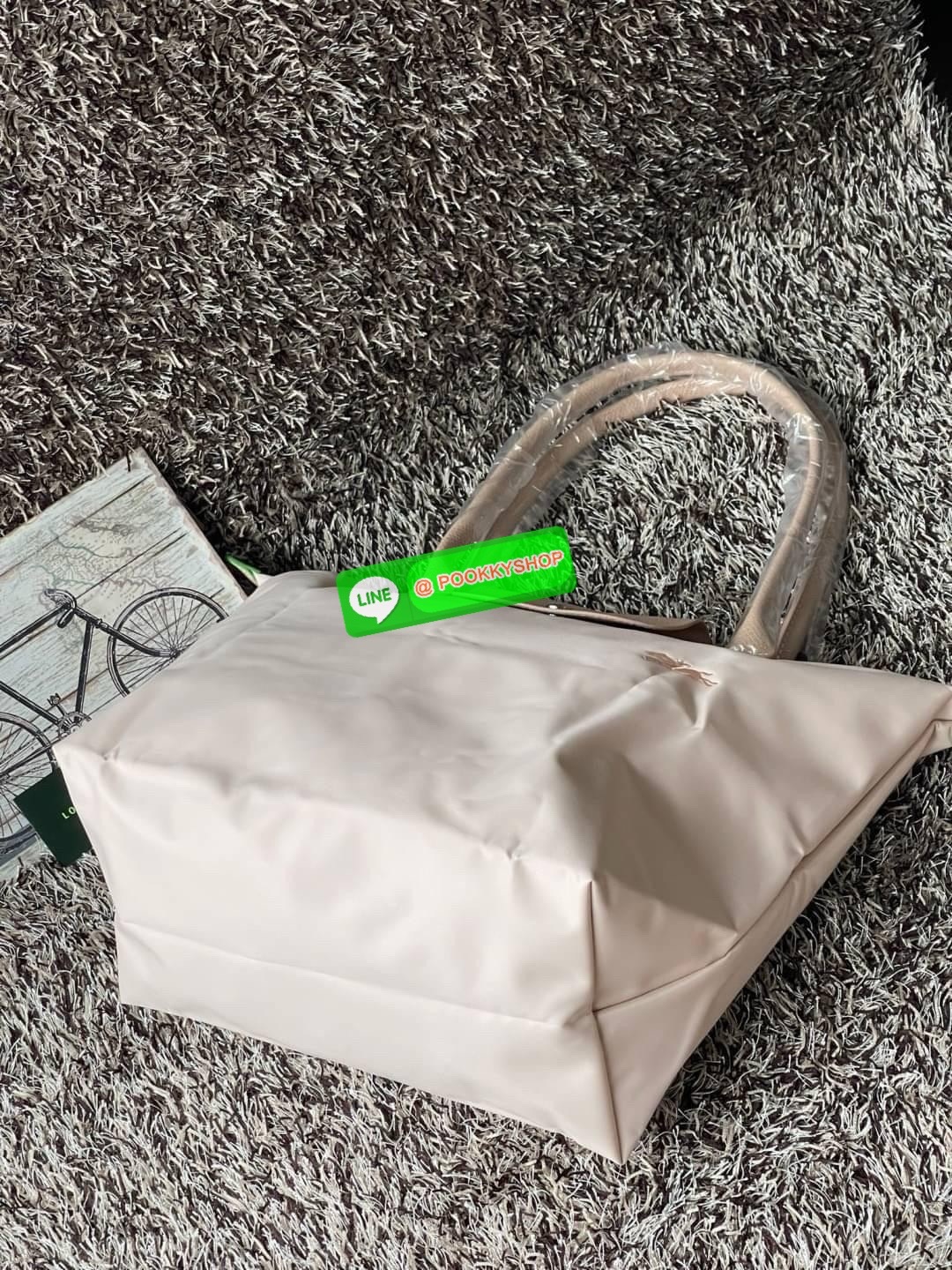 LONGCHAMP LE PLIAGE GREEN Shoulder bag L กระเป๋าโท้ทใบนี้ดึงดูดใจคุณด้วยรูปทรงมินิมอลและปริมาตรที่เพียงพอซึ่งสามารถเก็บเอกสารหรือแล็ปท็อปทั้งหมดของคุณได้อย่างง่ายดาย ด้ามยาวช่วยให้คุณสวมใส่ได้อย่างสบายบนไหล่ ขณะที่การปิดด้วยซิปช่วยให้มั่นใจได้ว่าสิ่งของทั