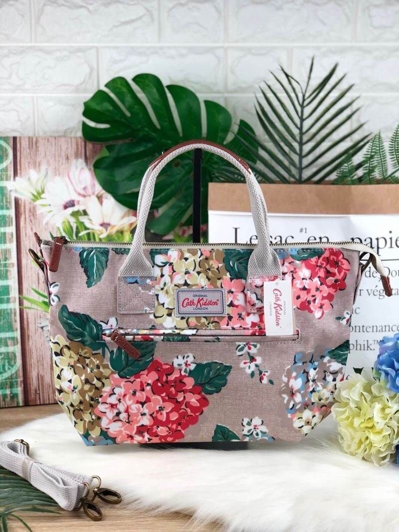 CATH KIDSTON HANDBAG กระเป๋าถือ/สะพายทรงสวย ด้านหน้ามีช่องซิปใส่ของจุกจิกได้ มีหมุดรองฐาน 4 มุม หูหิ้วมีหนังรองมือ เปิดปิดด้วยซิปบน ด้านในกว้างจุของได้เยอะ มีช่องซิปเล็ก 1 ช่อง มาพร้อมสายสะพายยาวถอดและปรับสายได้ รุ่นนี้น้ำหนักเบา ใช้งานง่ายได้หลายโอกาส มี