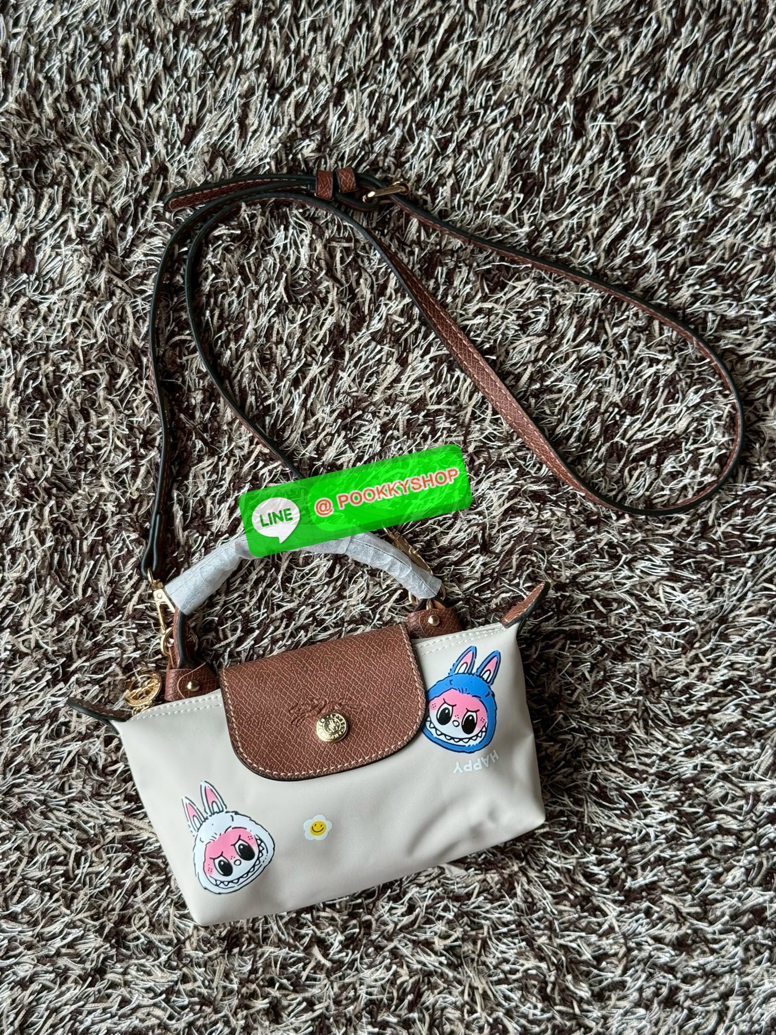 LONGCHAMP LE PLIAGE ORIGINAL X Labubu Pouch with handle เป็นการร่วมงานกัระหว่างแบรนด์ และยังกระเป๋าถือขนาดมินิทรงpouch ที่ด้านหน้ามีลวดลายน้องลาบูบู้ในแบบต่างๆ เปิดปิดระบบสองชั้น ได้ว่าของด้านในมีความปลอดภัย เหมาะอย่างยิ่งสำหรับสาวๆที่ชอบกระเป๋าขนาดมินิไซ