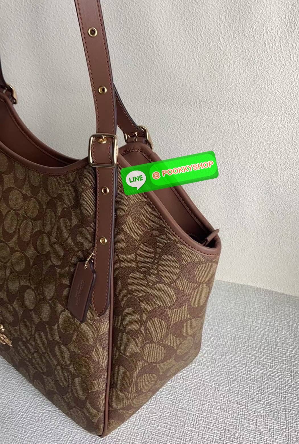 รุ่น: Coach CM076 – Gallery Tote In Signature Canvas • รายละเอียด: กระเป๋าทรง Tote รุ่น Gallery ลาย Signature Canvas คลาสสิก ตัดขอบหนังแท้สีดำเข้ม สายสะพายคู่ปรับระดับได้ ภายในกว้าง ใส่ของทำงานหรือเรียนได้สบาย มีช่องซิปหลัก 1 ช่อง และช่องเสริมด้านในอีกหลา