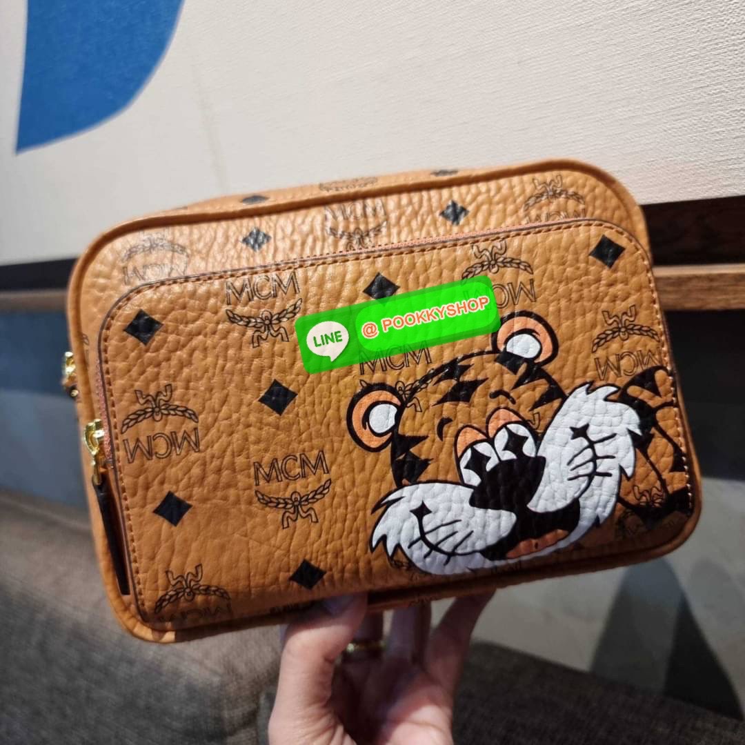 MCM KLASSIK CROSSBODY IN NEW YEAR TIGER VISETOS ใหม่ล่าสุด คอลเลคชั่นรับปีเสือ ของมันต้องมี กระเป๋าสะพายข้างทรงครอสบอดี้ โดดเด่นด้วยลายพริ้นท์น้องเสือคมสวย รุ่นนี้หนุ่มๆหรือสาวๆก็สะพายได้น้า ขนาดกำลังดี วัสดุหนังแคนวาสคุณภาพดี มีช่องหลัก 2 ช่อง เปิด-ปิดด้