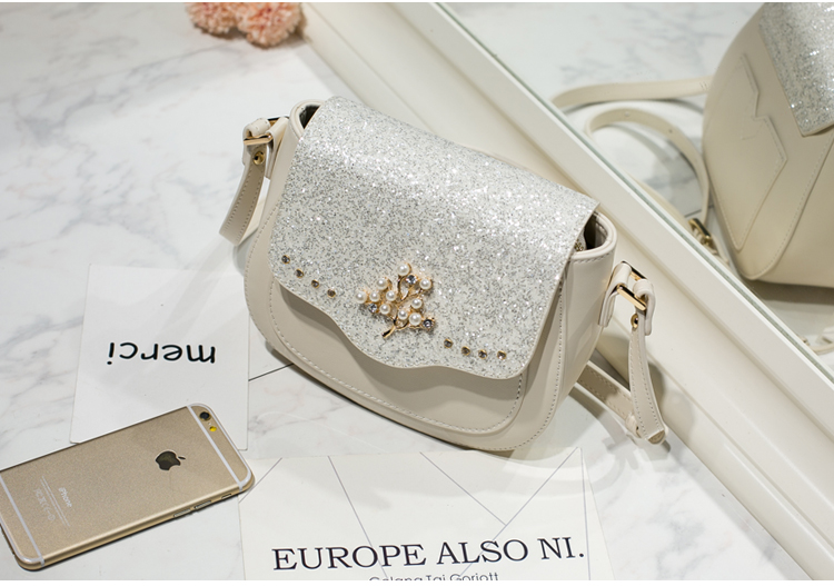 AXIXI กระเป๋าแฟชั่นสตรี รุ่น Tree Pearl สีขาว Off White กระเป๋าสะพายแฟชั่นทรง Saddle สุดน่ารัก เพิ่มความโดดเด่นให้กระเป๋าด้วย Daimond Dust สุดหรูหรา เพิ่มดีเทลให้กับกระเป๋าด้วยอุปกรณ์แต่งกระเป๋าลายต้นไม้สีทองประดับด้วยมุขดูสวยงาม ตัวกระเป๋าผลิตจากหนัง PU
