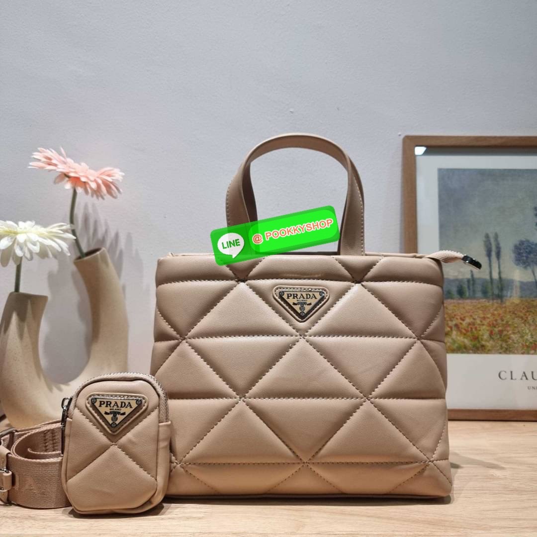 PRADA LEATHER PADDED BAG ใหม่ล่าสุด กับคอลเลคชั่นที่ทำออกมาตอบโจทย์ได้ทุกไลฟ์สไตล์ และเป็นยูนิเซ็กส์ กับกระเป๋าทรงโท้ท ขนาดกำลังดี วัสดุหนังแท้ ตัดเย็บเดินเส้นลายตาราง ปากกระเป๋ามีซิปเปิดปิด ภายในเป็นช่องโล่ง มีช่องแยกให้ มาพร้อมสะพายข้างและใบลูก ให้ได้สน