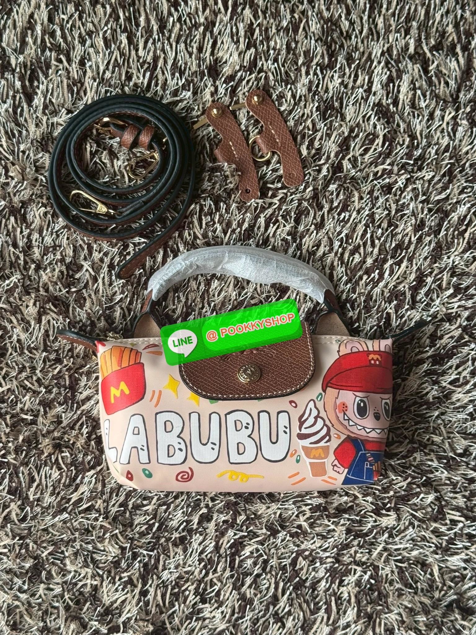 LONGCHAMP LE PLIAGE ORIGINAL X Labubu Pouch with handle เป็นการร่วมงานกัระหว่างแบรนด์ และยังกระเป๋าถือขนาดมินิทรงpouch ที่ด้านหน้ามีลวดลายน้องลาบูบู้ในแบบต่างๆ เปิดปิดระบบสองชั้น ได้ว่าของด้านในมีความปลอดภัย เหมาะอย่างยิ่งสำหรับสาวๆที่ชอบกระเป๋าขนาดมินิไซ