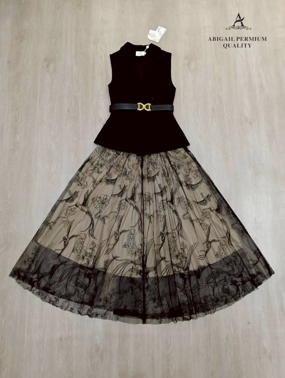 เสื้อแขนกุดเบลเซอร์สีดำ ดีไซน์คอวีลึก เพิ่มความเรียบหรูพร้อมกระดุมด้านหน้าและกระเป๋าดีไซน์เรียบเท่ ดึงความสนใจด้วยเข็มขัดหนังหัวสีทองที่ช่วยเน้นทรวดทรงและเพิ่มความพรีเมียม กระโปรงยาวทรงเอ ผ้าซีทรูสองชั้น ด้านในเป็นผ้าสีเบจเรียบ ส่วนด้านนอกเป็นผ้าทูลล์สีดำ